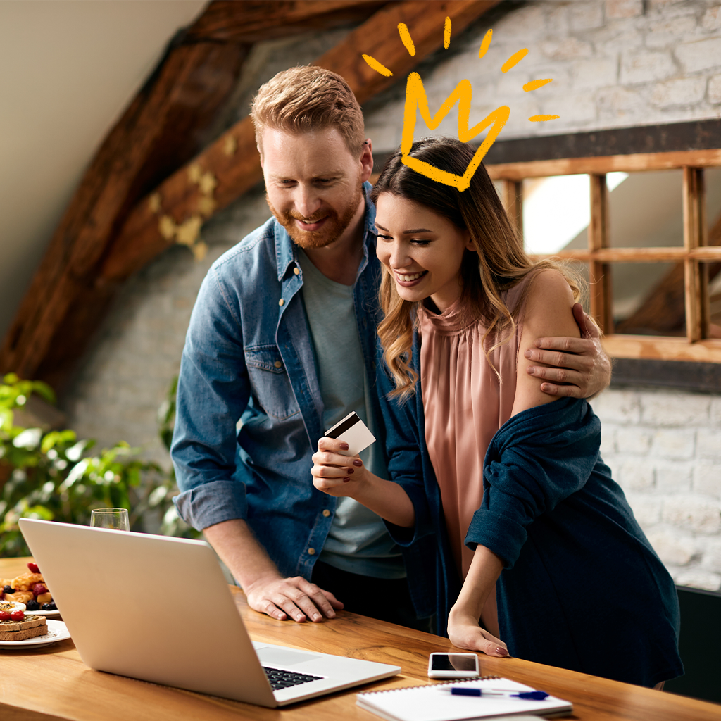 Young couple smiling while looking on their computer